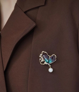 Broche papillon élégante avec dégradé violet et perle sur le revers d'une veste chic