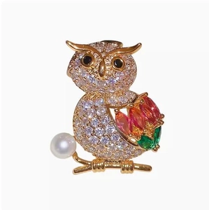 Detailed owl brooch with sparkling zircons, colorful gemstones, and a white pearl accent