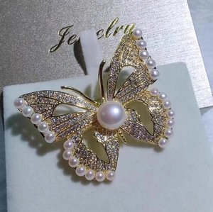 Élégante broche papillon avec oxydes de zirconium brillants et grandes perles dorées