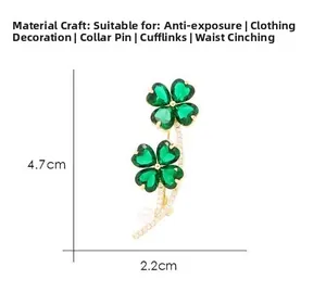 Macro detail of green four-leaf clover brooch in gold finish with 4.7cm x 2.2cm size label