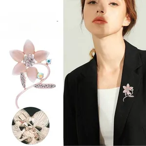 Vues détaillées d'une broche fleurie avec pétales roses et strass portés par un mannequin