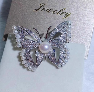 Détail de la broche papillon en argent avec ailes en zircon et accents de perles