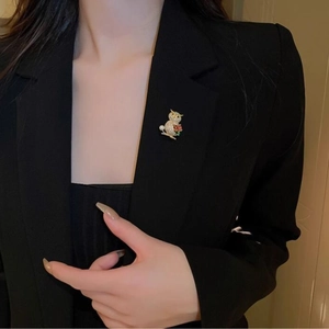 Elegant owl brooch with white rhinestones and pearl on a black suit lapel