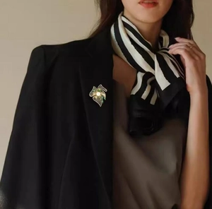 Broche fleur dorée raffinée avec perle sur blazer noir pour un look professionnel
