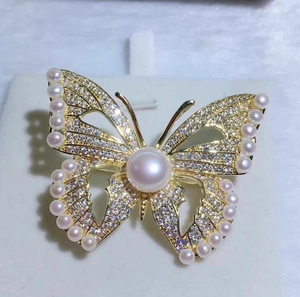 Vue rapprochée d'une broche papillon avec cristaux de zircon brillants et perles blanches