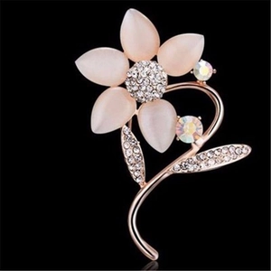 Détail d'une broche fleur avec pétales en œil de chat rose et strass scintillants