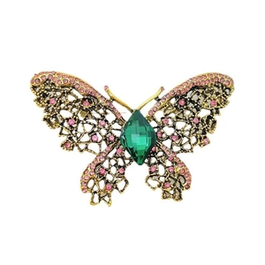 Broche papillon vintage avec gemme verte et cristaux roses sur fond blanc de haute qualité
