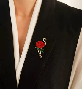 Broche élégante flamant rose et rose rouge avec cristaux sur un revers de blazer noir