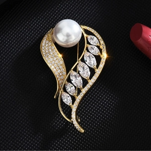 Broche feuille dorée élégante avec perle et zircons scintillants sur fond noir