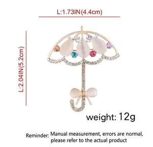 Broche parapluie dorée avec opales blanches et cristaux colorés, dimensions 4,4cm par 5,2cm