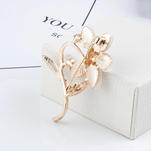 Détail du revers d'une broche fleur dorée montrant l'épingle de sécurité et la texture