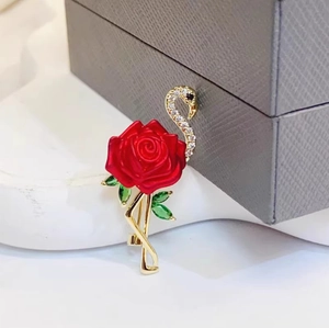 Broche flamant rose exquise avec rose rouge et diamants étincelants sur métal doré