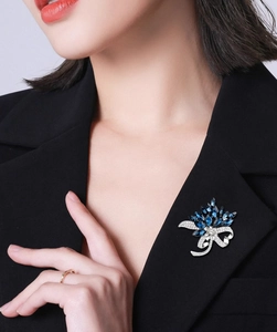 Detail of elegant blue crystal bouquet brooch pinned on a black suit lapel