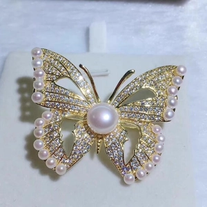 Broche papillon élégante avec cristaux scintillants et perles blanches dorées