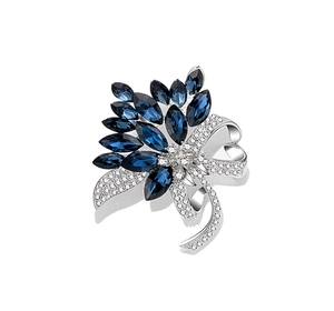 Detailed view of bouquet brooch with dark blue gemstones and a sparkling silver bow