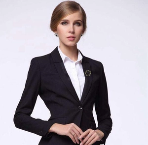 Detail of vintage round brooch with green stones pinned on a black business suit lapel
