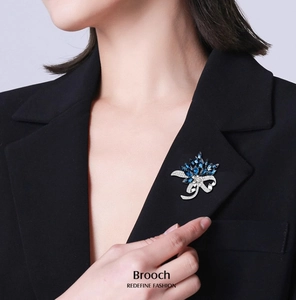 Detailed view of a navy blue gemstone flower brooch pinned to a black suit lapel