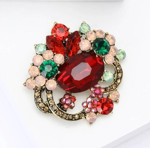 Detail showing vintage gold alloy flower brooch with red crystals and colorful rhinestones