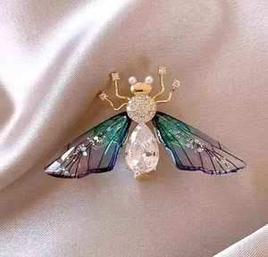 Detailed view of an insect brooch with a large teardrop zircon and gradient wings