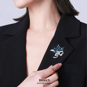 Elegant deep blue gemstone bouquet brooch with silver crystals on a black suit lapel