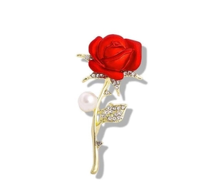 Detail of red rose brooch with gold stem, shimmering rhinestones and a white pearl