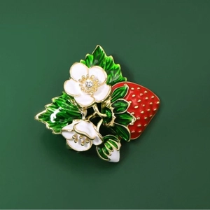 Broche fraise élégante en émail rouge avec fleurs blanches et feuilles vertes sur base dorée
