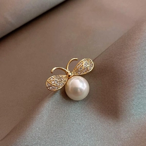 Detail of bee brooch with large pearl body and sparkling crystal-set gold wings