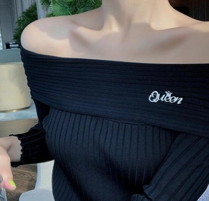 Detail der Queen-Bestickung und Krone auf dem schwarzen schulterfreien Rippstrickoberteil