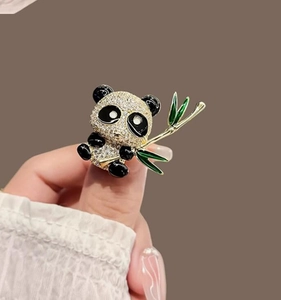 Détail macro d'une broche panda sertie de cristaux tenant des feuilles de bambou