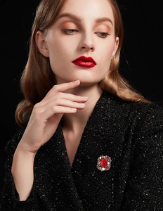 Detail of vintage square red crystal brooch with pearls on a black tweed coat
