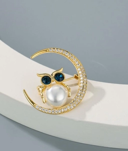 Detailansicht der Mond-Eule-Brosche mit weißen Perlen und tiefblauen Edelsteinen