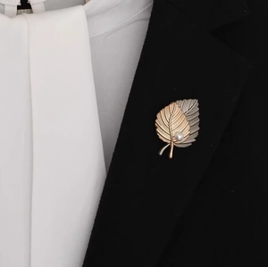 Elegant maple leaf brooch with pearl on black suit jacket lapel for formal wear