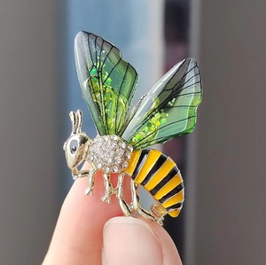 Exquisite bee brooch with green glitter wings and crystal accents on alloy base