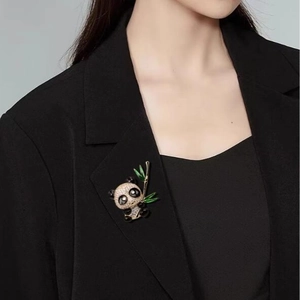 Broche panda exquise avec cristaux étincelants et bambou sur le revers d'un blazer noir