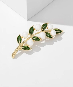 Détail d'une broche feuille de tournesol dorée avec perles et détails en émail vert foncé