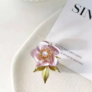 Elegant pink enamel camellia brooch with white pearl center and gold leaf details