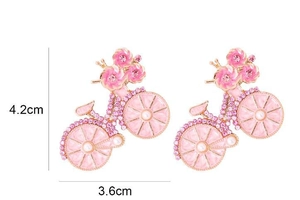 Detail van vintage roze fietsbroche met strassteentjes en bloemenwielen