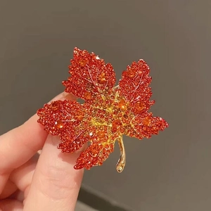 Exquisite gold-plated maple leaf brooch with orange crystals and sparkling rhinestones
