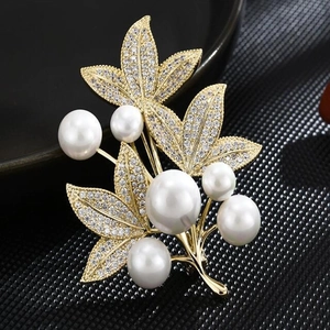 Luxurious gold floral brooch featuring white pearls and micro-pave leaf crystals