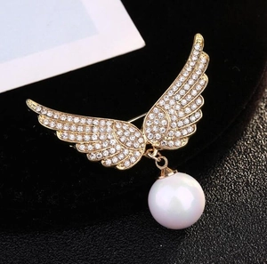 Broche ailes d'ange dorées avec cristaux et un pendentif en perle blanche suspendu