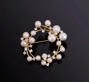 Detailed macro view of the luxury pearl and zircon wreath brooch on a reflective black surface