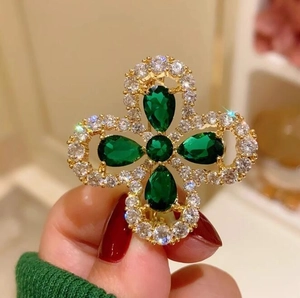 Élégante broche trèfle à quatre feuilles dorée avec pierres vert émeraude et zircons