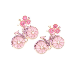 Detail van roze fiets oorbellen met fonkelende strass steentjes en witte parels op vergulding