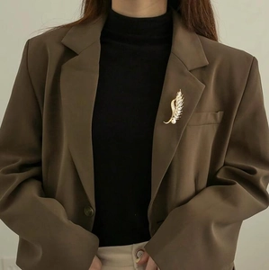Elegant gold wheat ear brooch with pearls and crystals on a dark brown suit jacket