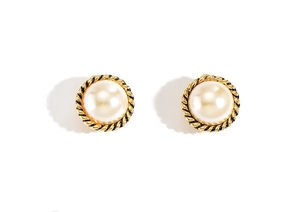 Detailed macro view of white faux pearl earrings with golden twisted rope frame decoration