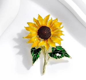Vue détaillée de la broche tournesol en émail jaune avec un accent de perle blanche