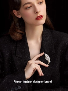 Elegant gold wheat ear brooch with pearls and crystals on a black suit blazer