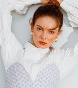 Close-up of model wearing vintage style large faux pearl earrings with golden rope borders