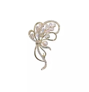 Gros plan d'une broche papillon de luxe avec cristaux brillants et perle blanche