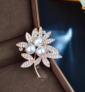 Elegant rose gold flower brooch with three large pearls and shimmering crystal leaves